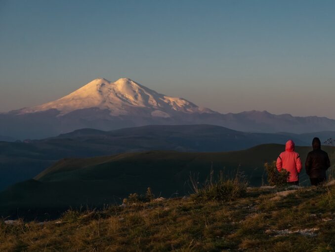 Туристы смотря на Эльбрус - в Кисловодске в апреле нужно одеваться теплее
